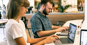 SEO Melbourne 3 Team collaboration in a digital workspace with laptops, remote workers, and online productivity tools.